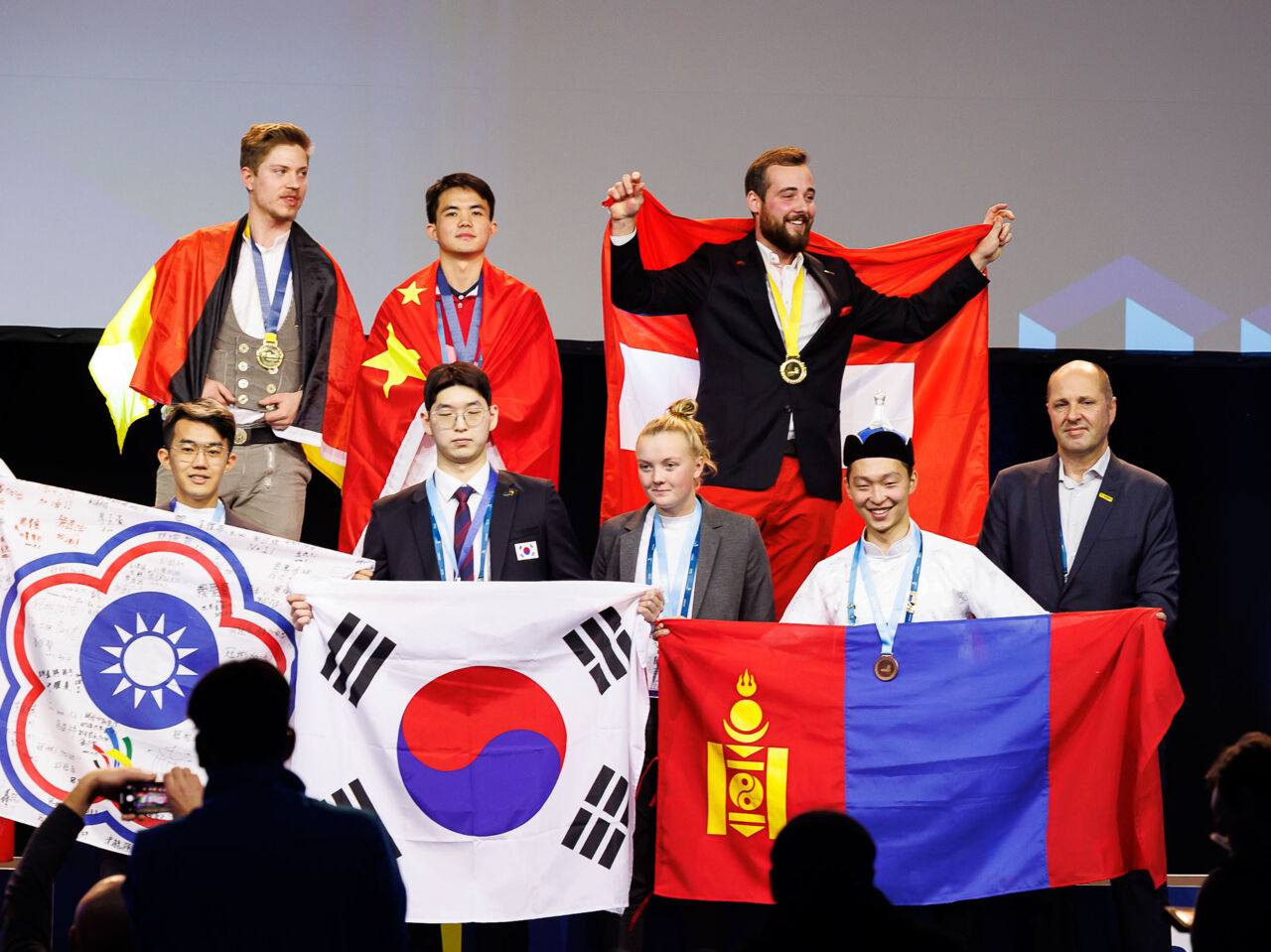 ry Astrup Hansen on stage being presented with a Medallion for Excellence and the Best of Nation award from the Danish team for competed in Bricklaying at WorldSkills Competition 2022 Special Edition.